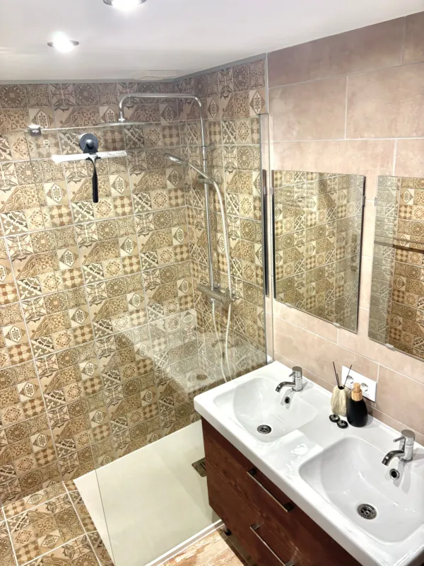 Badkamer met douche en twee wasbakken